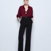 Wide-leg pants with a monogram button - Access Fashion